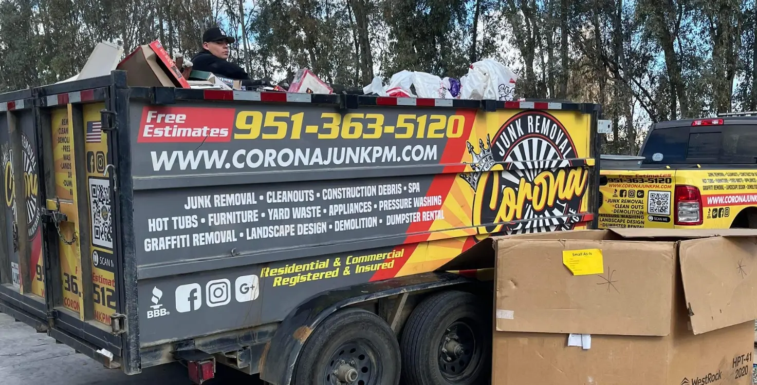 Employee of Corona Junk Removal & Property Maintenance LLC loading up cardboard & junk from a school campus clean out.