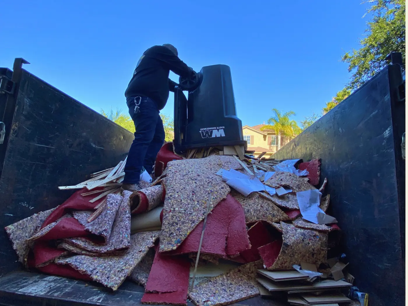 Corona Junk Removal crew removing and loading old carpet